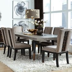 a dining room table and chairs in front of a large window