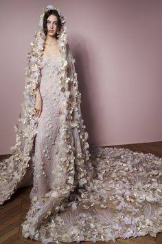 a woman in a wedding dress with flowers on the skirt and veil over her head