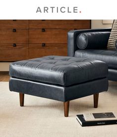 a black leather chair and ottoman in a living room