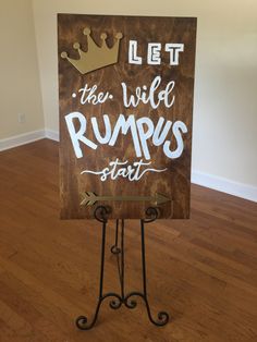 a sign that says let the wild rumps start with a crown on it in front of a wood floor