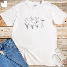 A cute aesthetic floral t-shirt featuring 4 wild flowers, perfect for adding a touch of nature to your wardrobe. This softstyle unisex t-shirt is made from 100% ring-spun cotton, offering a lightweight and blissful wearing experience year-round. The classic fit with crew neckline makes it versatile for any occasion, whether formal or semi-formal. Ideal for those who appreciate floral designs and want a comfortable, sustainable top. Product features - Made from durable and smooth ring-spun cotton fabric - Classic fit with crew neckline for versatility - Ethically grown and harvested US cotton - Variety of fabric blends for different color options - Pearlized, tear-away label for comfort Care instructions - Do not dryclean - Machine wash: warm (max 40C or 105F) - Do not bleach - Tumble dry: Spring Tops With White Screen Print, Botanical Plants Print Relaxed Fit T-shirt, Spring White Print Screen Printed Tops, Spring White Print Screen-printed Tops, White Print Screen Printed Tops For Spring, White Printed Screen Print Tops For Spring, Spring White Printed T-shirt, Spring Graphic Print White T-shirt, Spring White Print Graphic Tee