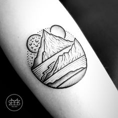 a black and white photo of a mountain tattoo on the right arm, with mountains in the background