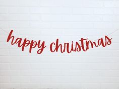 a red merry christmas banner hanging on a brick wall