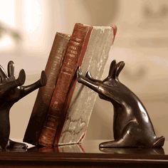 the bookend is made out of metal and has two mice on top of it