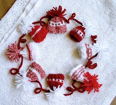 a knitted christmas wreath with red and white decorations