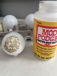 a bottle of mod podge next to some eggs