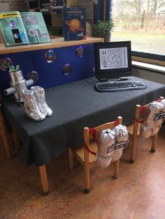 a laptop computer sitting on top of a table next to two fire hydrant sculptures