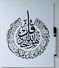 an arabic calligraphy is displayed on a piece of white paper with black marker markers