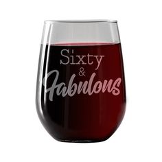 a red wine glass with the words sixty and fabulous on it's side, sitting in front of a white background