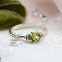 Make your proposal special with our peridot engagement ring!  August birthstone ring can be made in solid gold or sterling silver in delicate style.  Please choose from the material and ring size from the drop down menu. If you are looking to make this piece even more custom and special, feel free to contact me! We will find a way to make something specially for you.✨ DIAMOND DETAILS QUANTITY 6ps CARAT WEIGHT 0.045ct MEASUREMENTS 1,25mm CLARITY GRADE SI COLOR GRADE G Gemstone details Size: 5mm D Birthstone Engagement Rings August With Dimonds, Peridot Diamond Ring For May Birthstone, Elegant Lime Green Birthstone Promise Ring, Peridot Birthstone Ring In White Gold, Peridot Diamond Promise Ring With Center Stone, Peridot Diamond Ring With Center Stone For Promise, Peridot Diamond Promise Ring, Peridot Birthstone Diamond Ring Fine Jewelry, Classic Peridot Diamond Ring For Gift