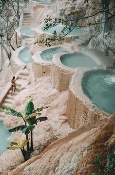 a woman is standing in the middle of an outdoor hot tub pool with steps leading up to it