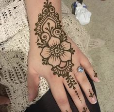 a woman's hand with henna tattoos on it