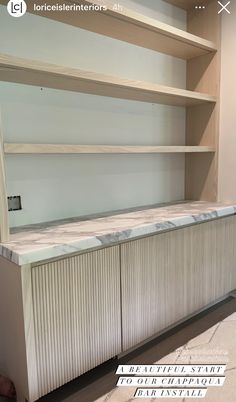 an empty bookcase with marble top and bottom shelves in a room that is being remodeled