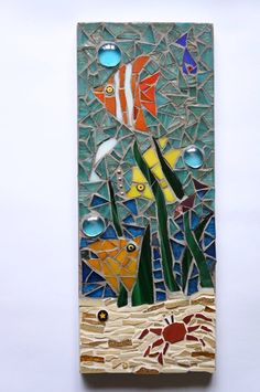 an art piece made out of stained glass with fish and seaweed on the bottom