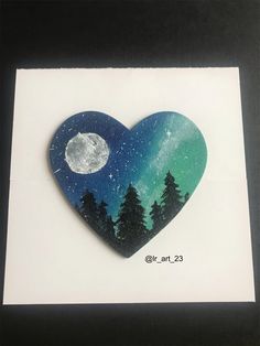 an image of a heart with trees and the moon painted on it