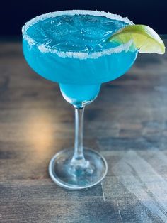 a blue cocktail with a lime garnish on the rim