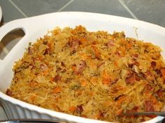 a casserole dish with carrots, bacon and bread crumbs in it