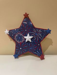 a red, white and blue star ornament sitting on top of a table