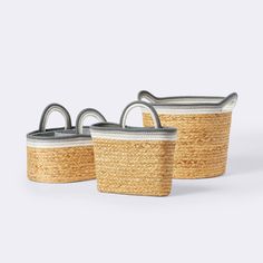 three woven baskets with handles and handles on each side, one in grey and the other in white