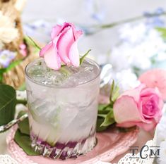 a pink rose sitting on top of a glass filled with ice