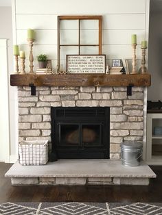 a fireplace with some candles and other items on top of it, in a living room