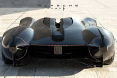 a black sports car parked on top of a sidewalk