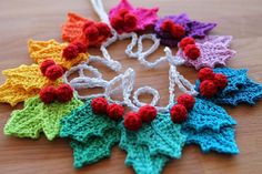 a crocheted christmas ornament with red, green, blue and yellow leaves