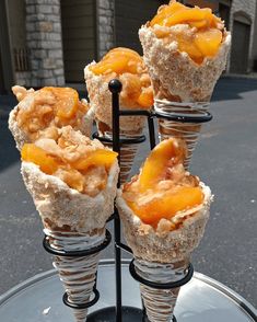 four desserts are stacked on top of each other and placed in individual cups to look like cones