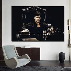 a man sitting at a table in front of a black and white photo on the wall