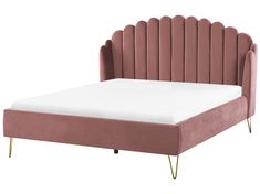 a pink bed with gold legs and headboard