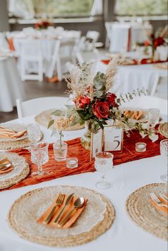 the table is set with place settings and flowers