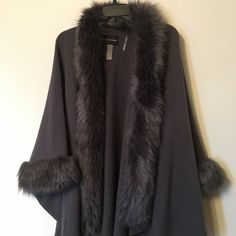 Dolce Cabo Classic Gray Poncho/Cape /Ruana With Faux Fur Trim Along Front And Sleeve Edge. 100% Acrylic 100% Faux Fur Trim Single Hook Closure Open Ended Arms W/Trim Approx. 32" Length At Longest Point Brand New W/O Tags ---- Never Been Worn! Size Is S/M But Because Of The Open Styling Will Fit Most Sizes From S To Xl All Items Ship From Smoke And Pet Free Home Bundle Multiple Items For Discount Respectful Offers Considered! My Items Are Priced Significantly Lower Than Suggested Retail Pricing. Cape Outerwear With Faux Fur Trim For Cold Weather, Fall Cape Outerwear With Faux Fur Lining, Faux Fur Trim Cape For Cold Weather In Fall, Fall Cape With Faux Fur Trim For Cold Weather, Fall Cape With Faux Fur Lining, Chic One-size Winter Outerwear, Fall Poncho With Faux Fur Trim Cape, Elegant Winter Shawl Outerwear, Elegant Fall Shawl Outerwear