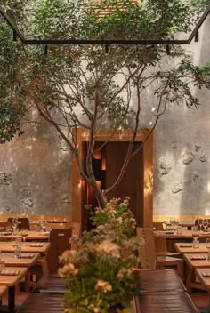 an indoor dining area with wooden tables and plants on the table, surrounded by metal wall panels