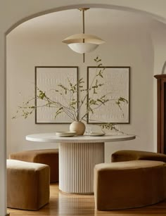 a dining room table with two chairs and a vase on it