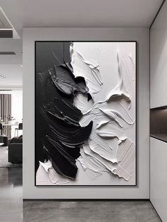 an abstract painting hangs on the wall in a modern living room with black and white decor