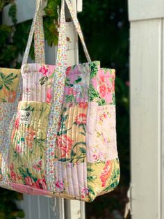 a multicolored bag hanging from a white door with green plants in the background