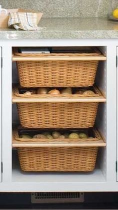 two wicker baskets are stacked on top of each other in front of a white cabinet