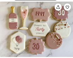 decorated cookies with pink and white frosting on a marble countertop for 30th birthday