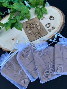 four pieces of cloth with rings on them sitting next to a tree slice and some green leaves