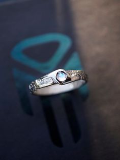 a close up of a ring on a table with a blue and white logo in the background