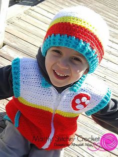 a young boy wearing a crocheted hat and jacket