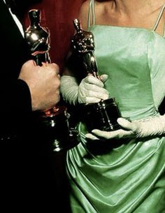 a woman in a green dress holding an oscar award