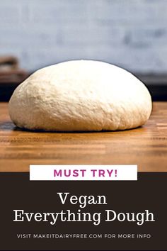 a loaf of bread sitting on top of a wooden table with the words must try vegan everything dough