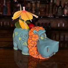 an elephant figurine with fruit in it's trunk sitting on a table