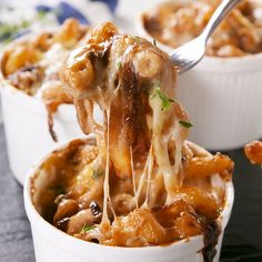 a spoon full of macaroni and cheese being lifted from the casserole dish