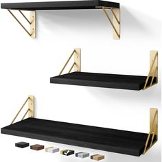 two black shelves with gold brackets on them