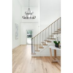 a white room with wood floors and a chandelier