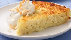 a close up of a slice of cake on a plate with whipped cream and coconut