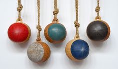 four different colored balls hanging from ropes