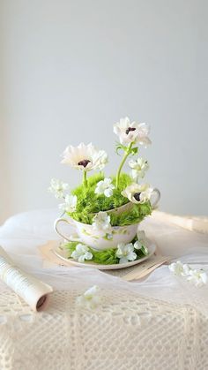 white flowers in a teacup on a table